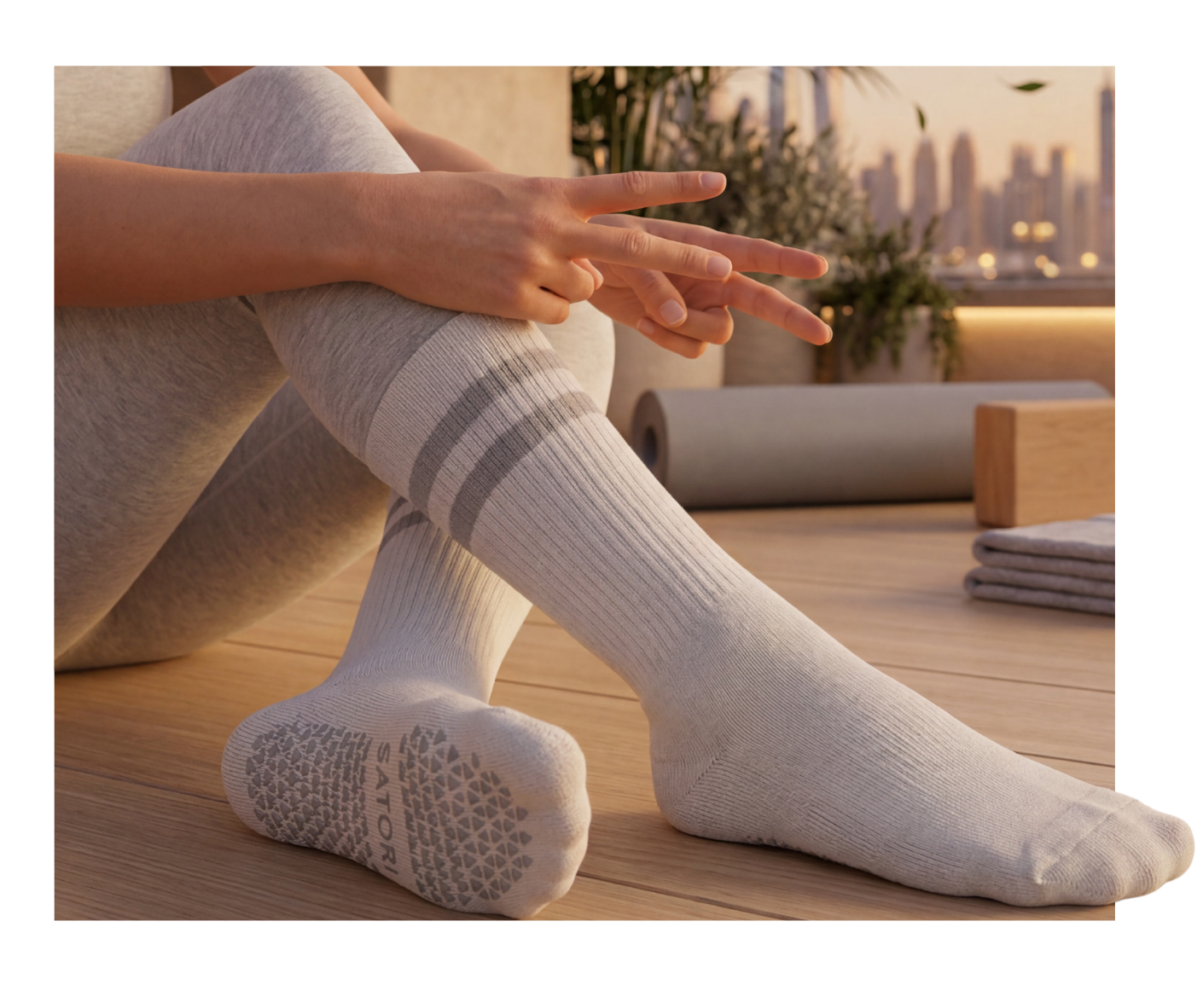 White Satori crew grip socks with black stripes on Pilates reformer, featuring non-slip sole for stability and balance.