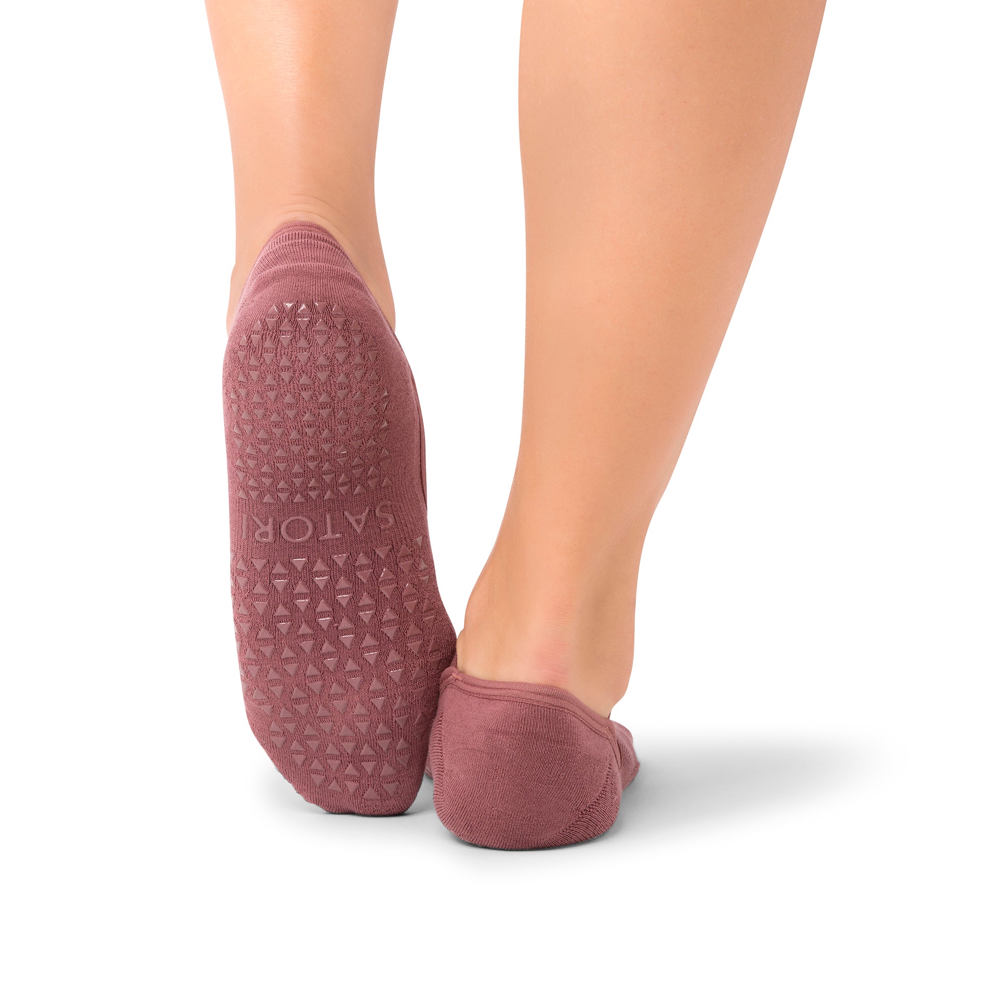 Naomi Acai Berry grip socks on woman’s feet during Pilates class in GCC