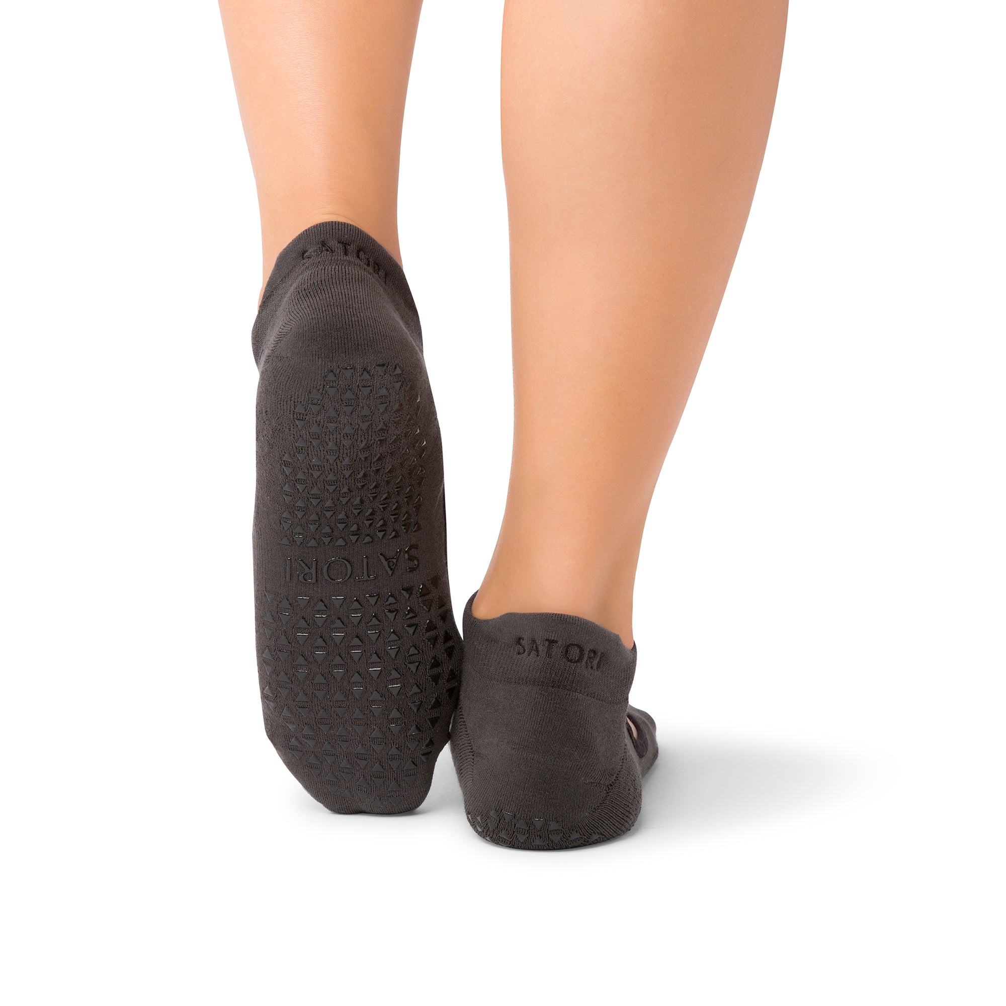 Elegant grip socks on a woman practicing yoga in a serene Middle Eastern setting
