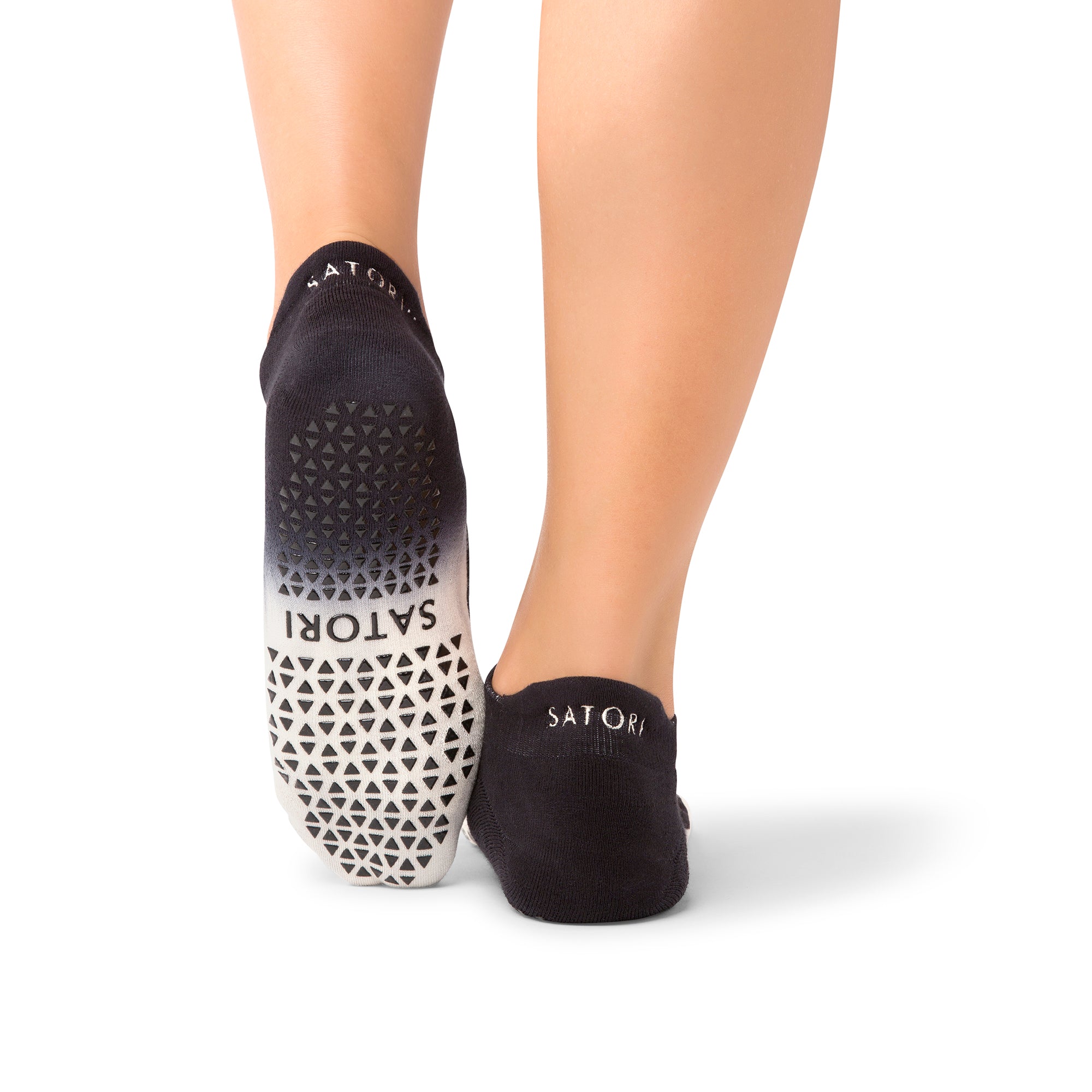 Elegant grip socks on a woman practicing yoga in a serene Middle Eastern setting