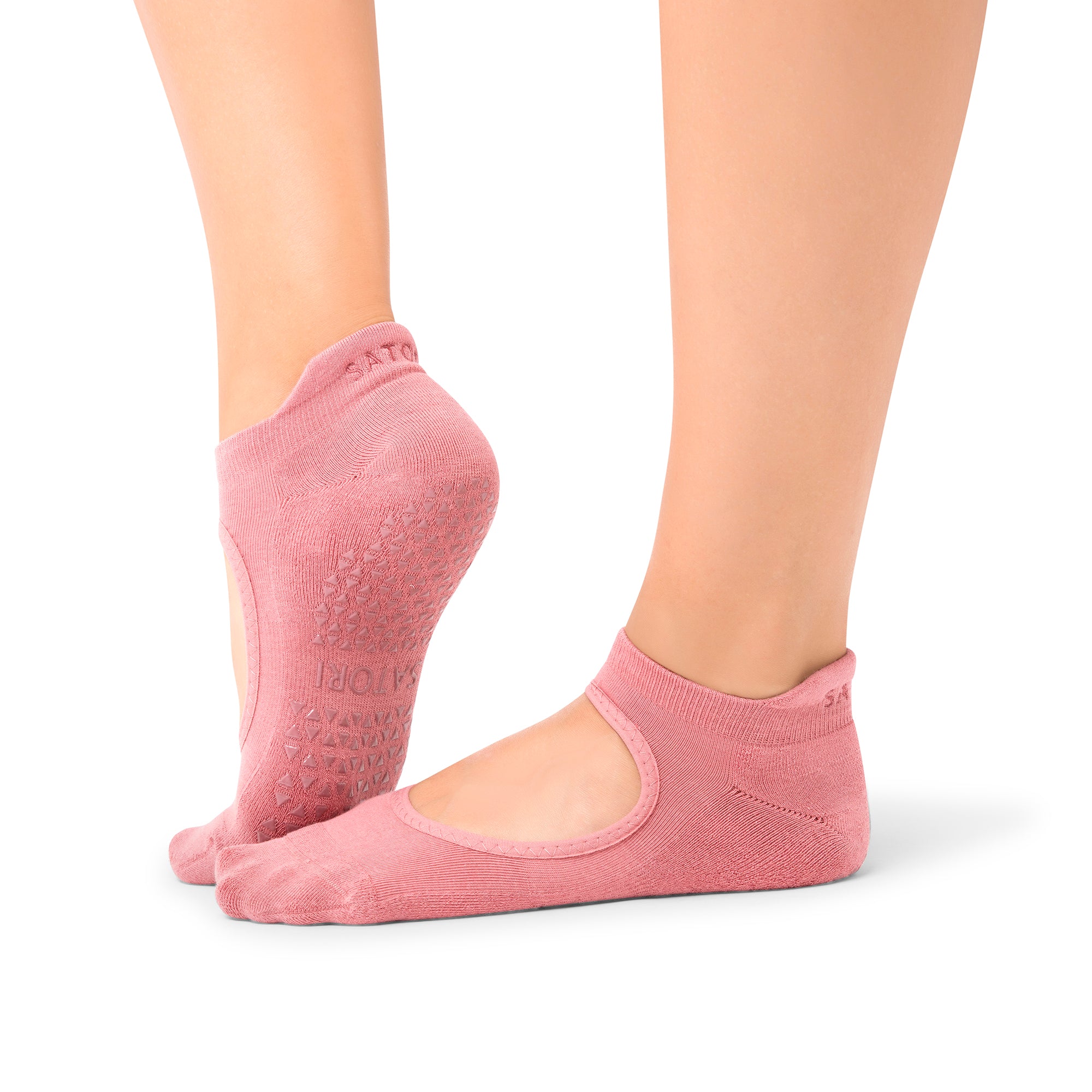 Woman stretching in a Dubai yoga studio wearing Aya Rosewood grip socks