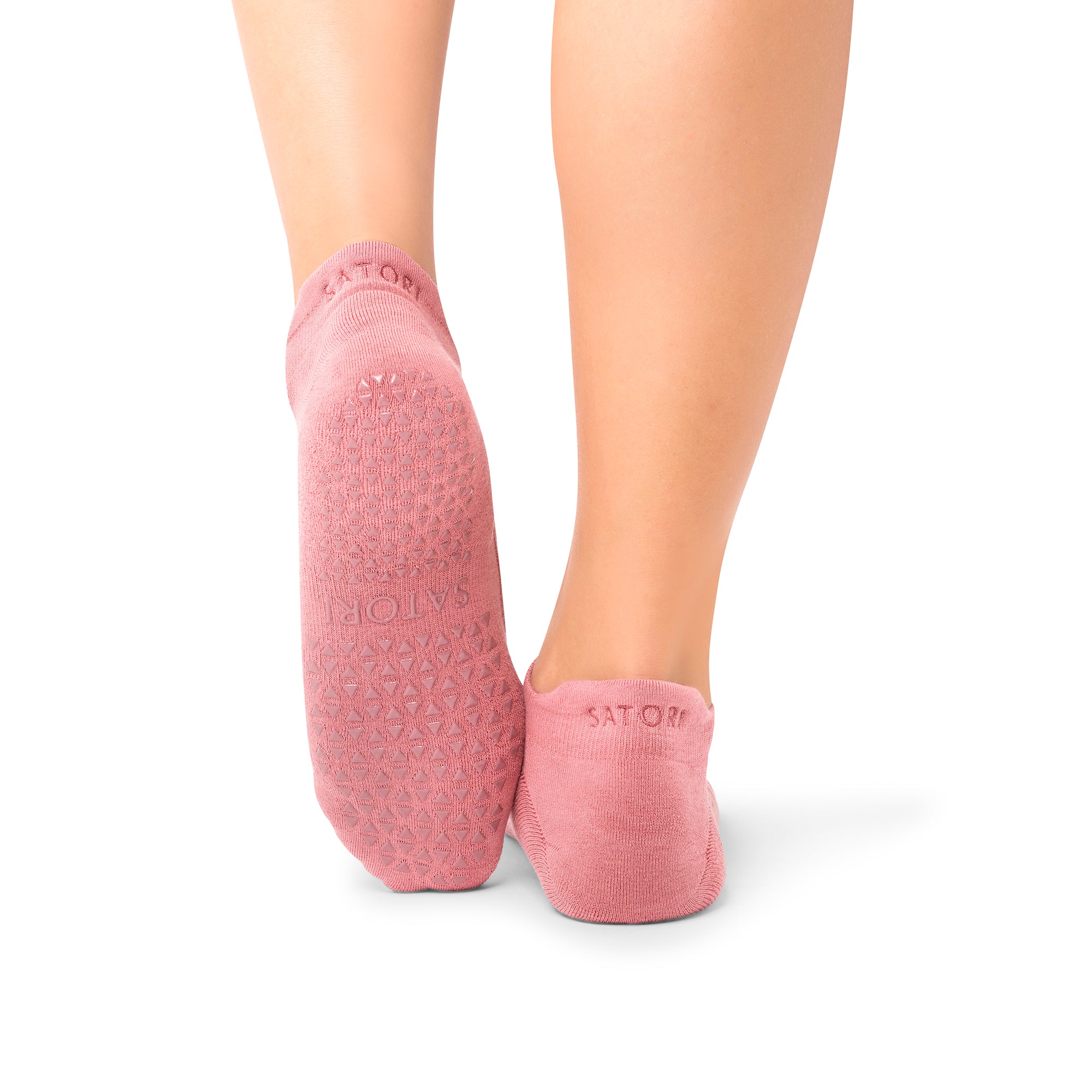 Elegant grip socks on a woman practicing yoga in a serene Middle Eastern setting