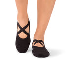 Dark-toned Naomi Midnight grip socks with cross straps worn in a UAE yoga studio