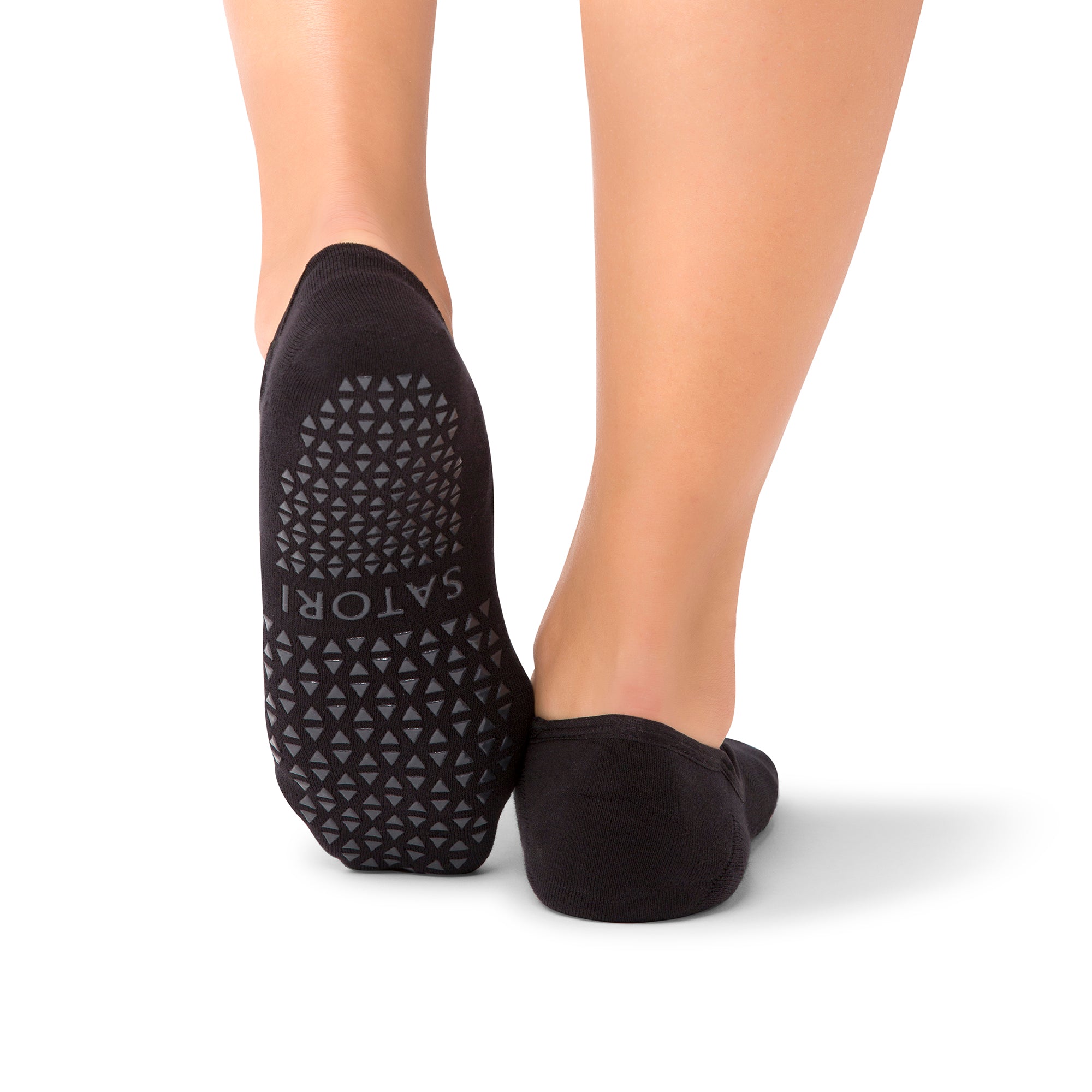 Close-up of Naomi Midnight grip socks worn during a barre class in a UAE studio