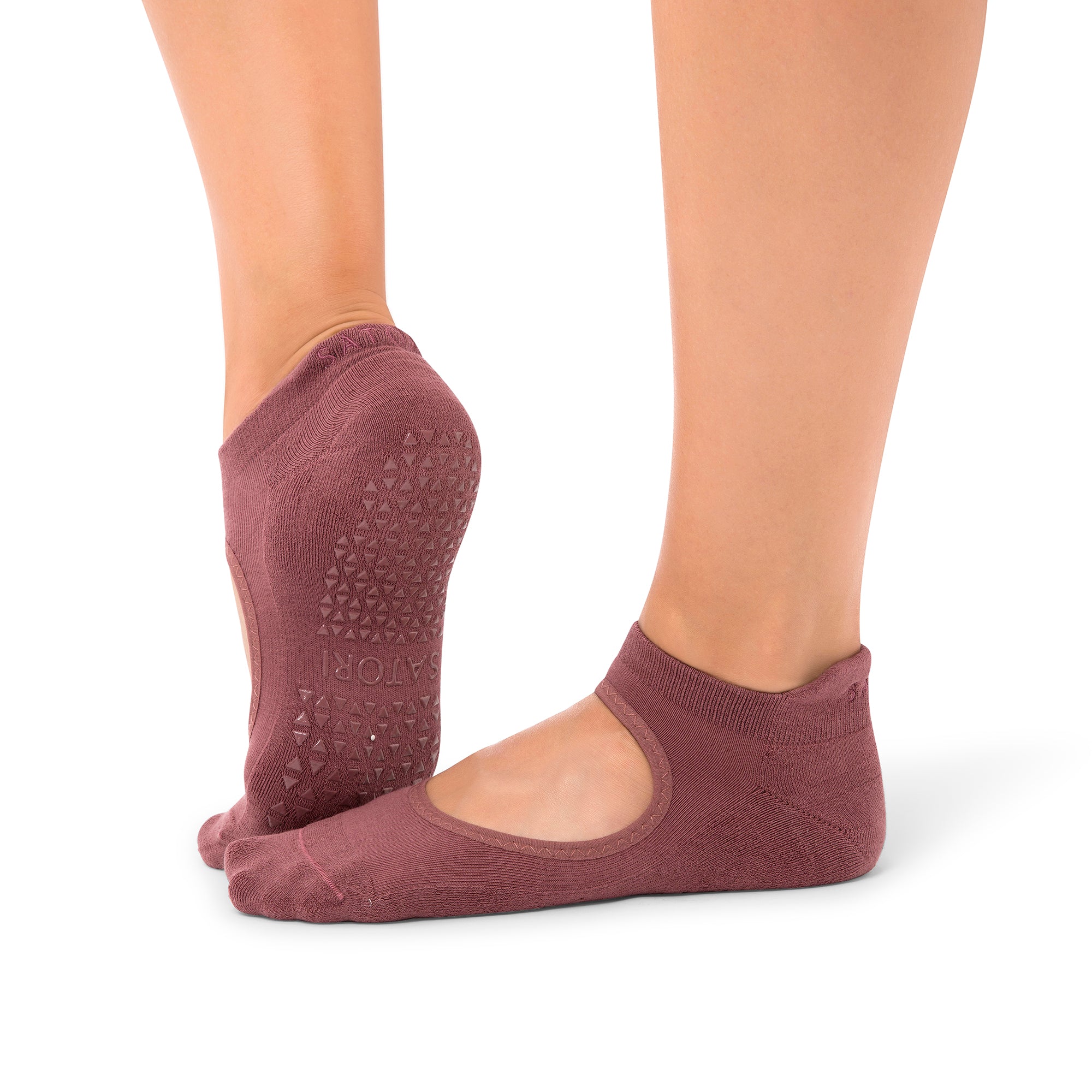 Close-up of organic Aya Acai Berry grip socks on wooden floor during Pilates