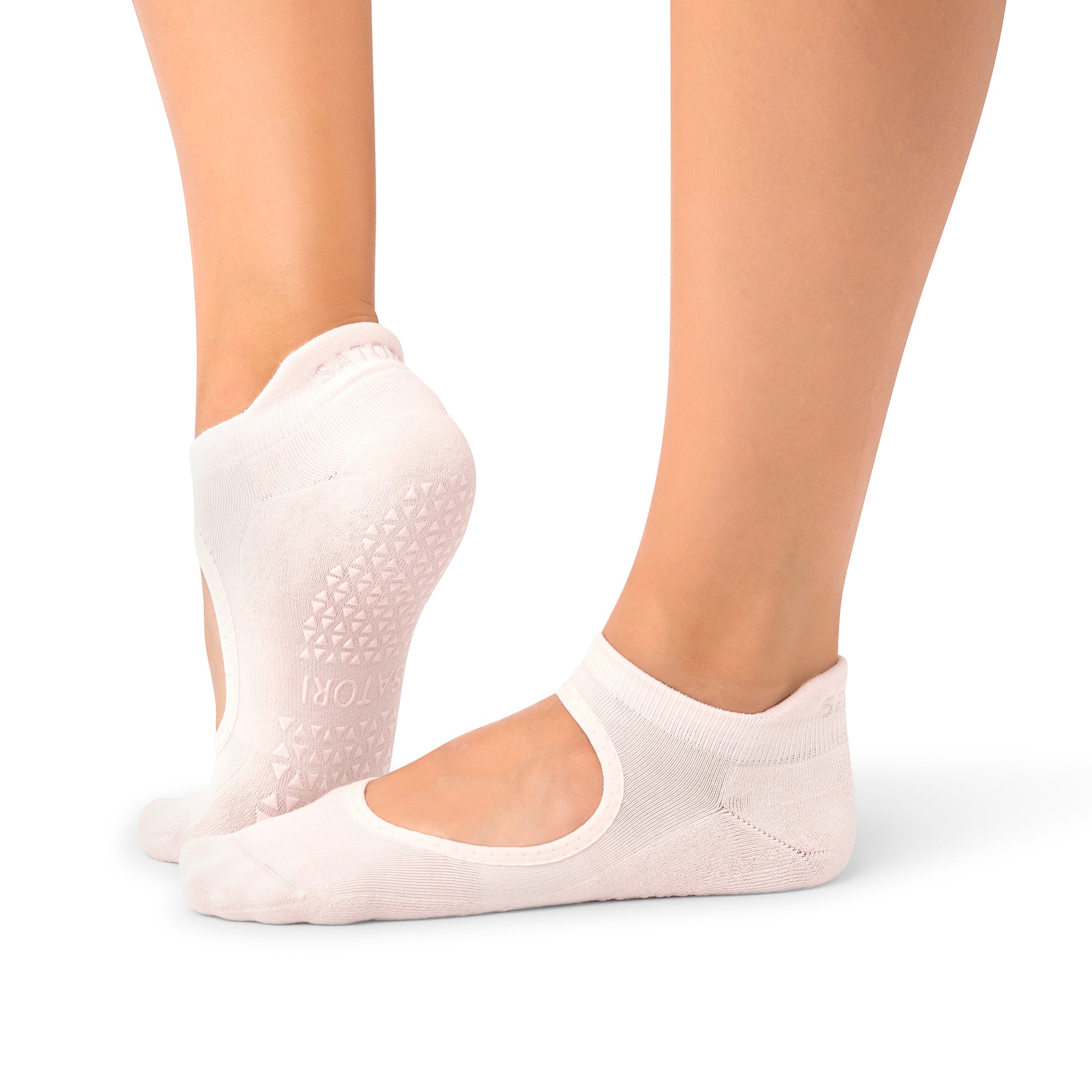 Close-up of organic Aya Petaluxe grip socks on wooden floor during Pilates